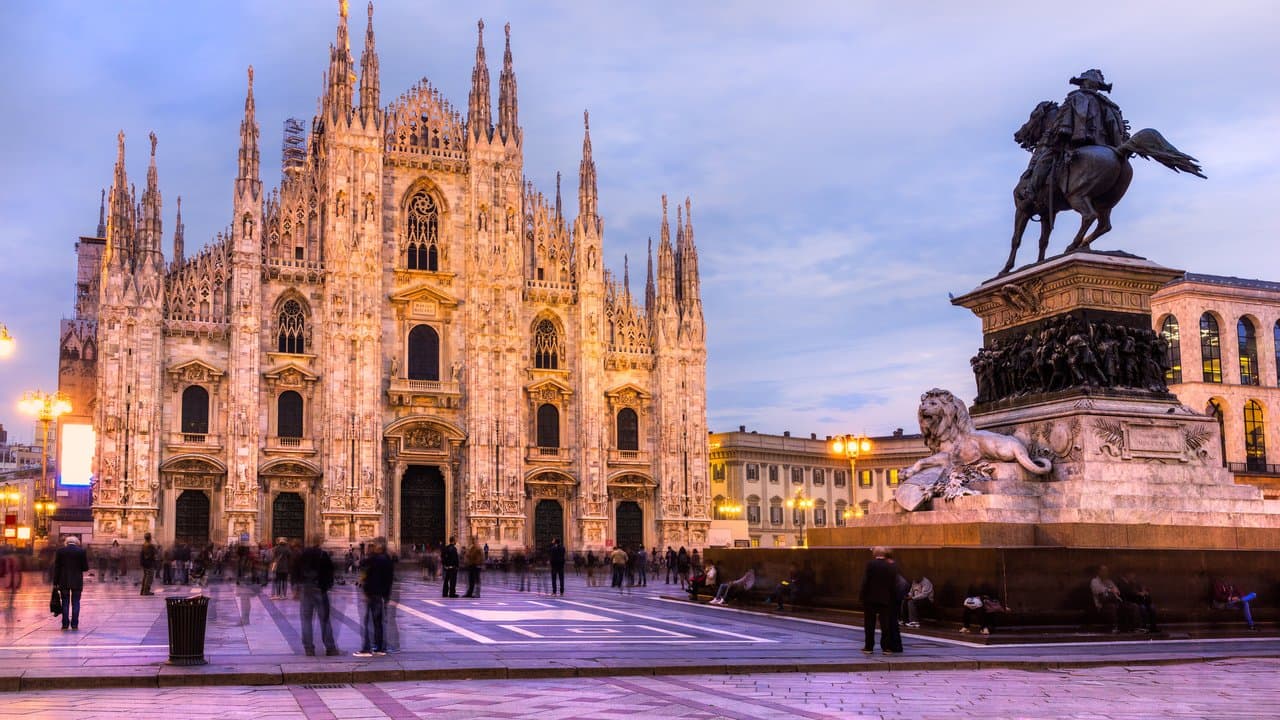 Duomo di Milano illuminato al crepuscolo con il monumento a Vittorio Emanuele II.